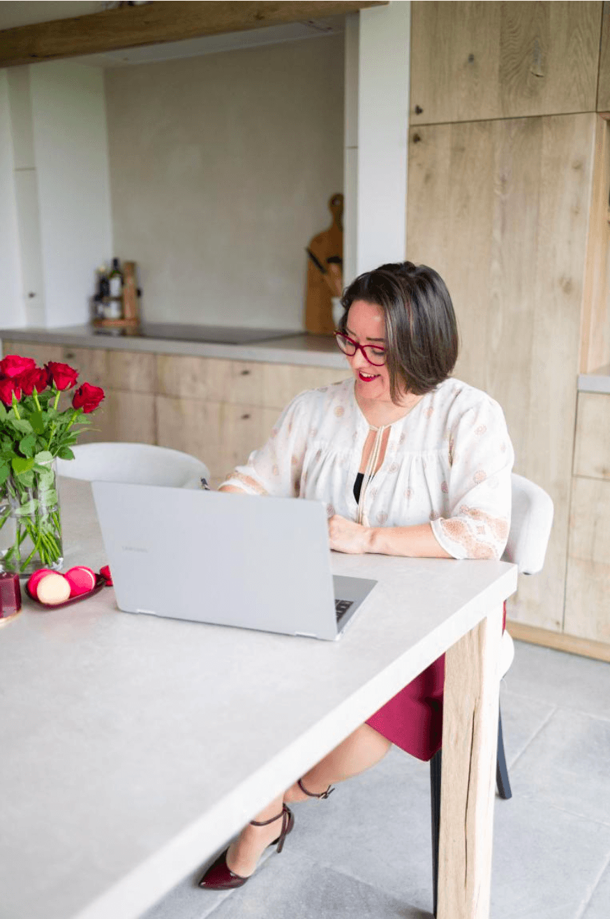Woman working on laptop in modern kitchen setting